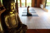 Buddha statue and woman performing yoga